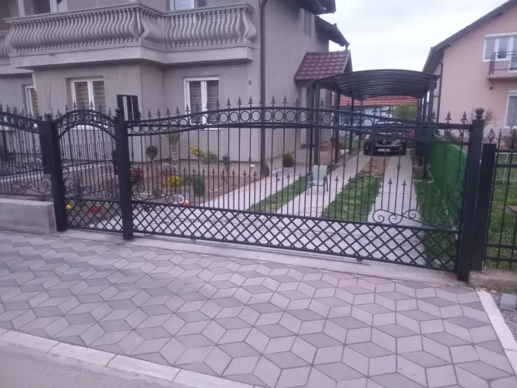 Klasična kovana kapija sa pešačkom kapijom crne boje.