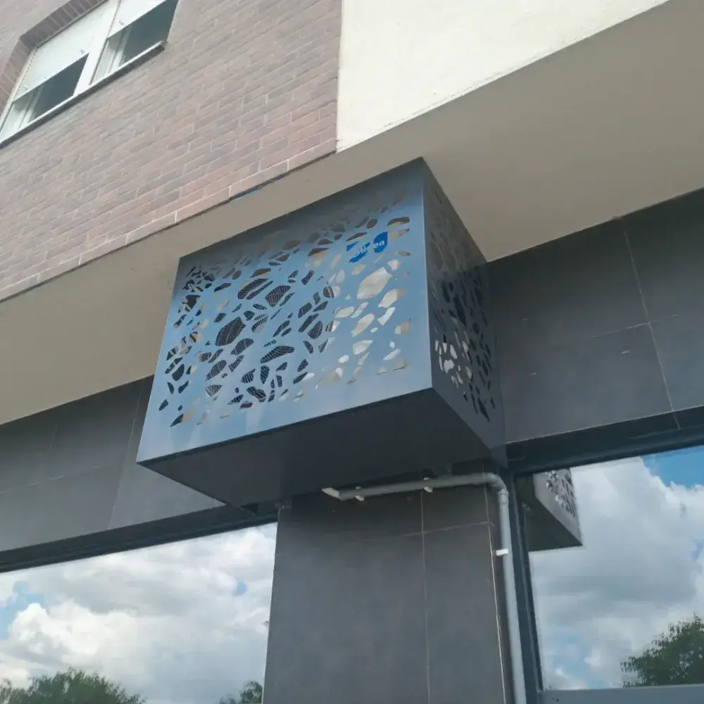 CNC laserski sečena maska za klimu na modernoj zgradi.
