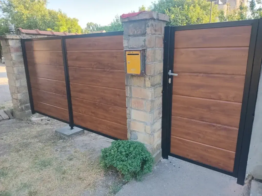 Panel kapija braon boje sa crnom metalnom konstrukcijom.